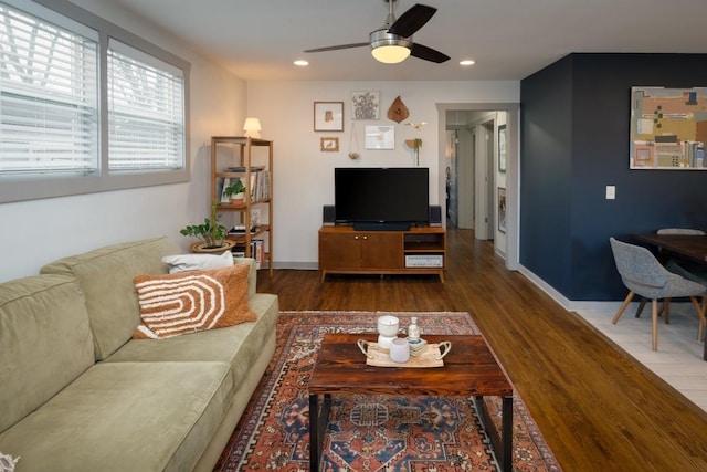 living room featuring ceiling fan and dark wood-type flooring