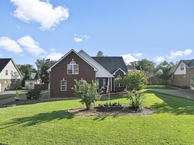 view of front of house with a front yard and a storage shed