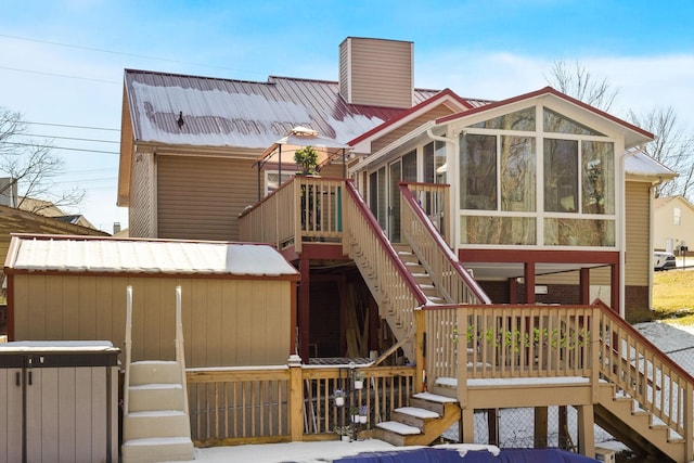 rear view of property with a wooden deck and a sunroom