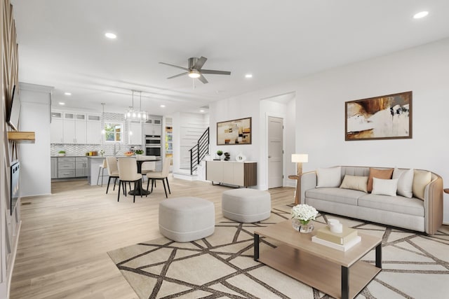 living room featuring ceiling fan and light hardwood / wood-style floors