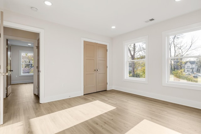 unfurnished bedroom with light hardwood / wood-style floors and a closet