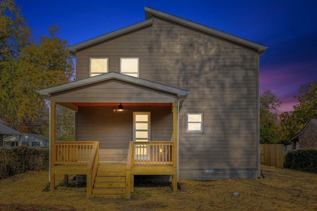 back house at dusk with a wooden deck