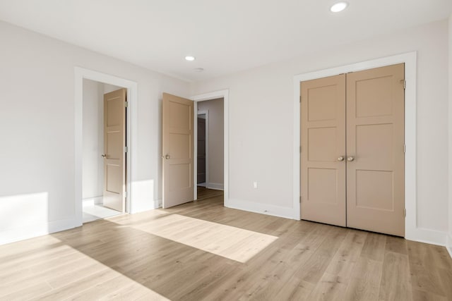 unfurnished bedroom with a closet and light hardwood / wood-style floors