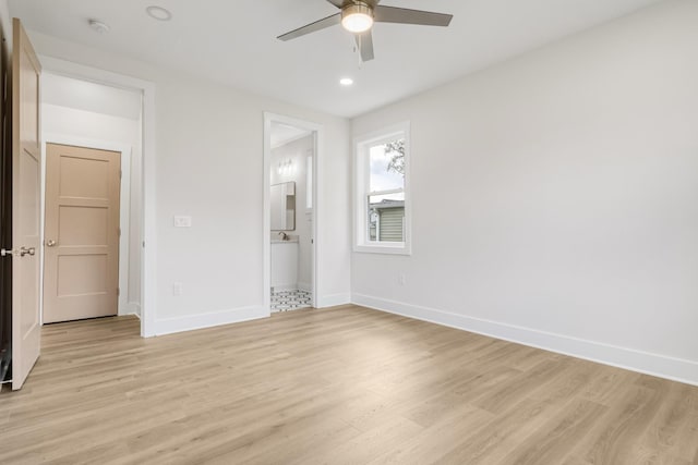 interior space with light hardwood / wood-style floors, ensuite bath, and ceiling fan