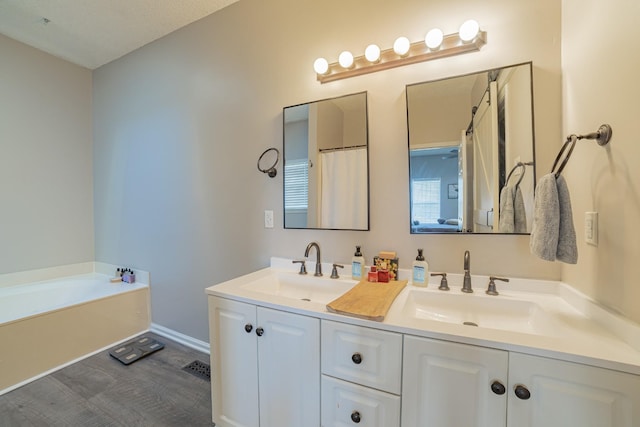 bathroom with a washtub, a textured ceiling, and vanity