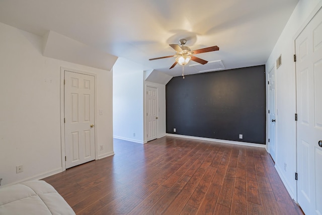 additional living space with ceiling fan, dark wood-type flooring, and vaulted ceiling