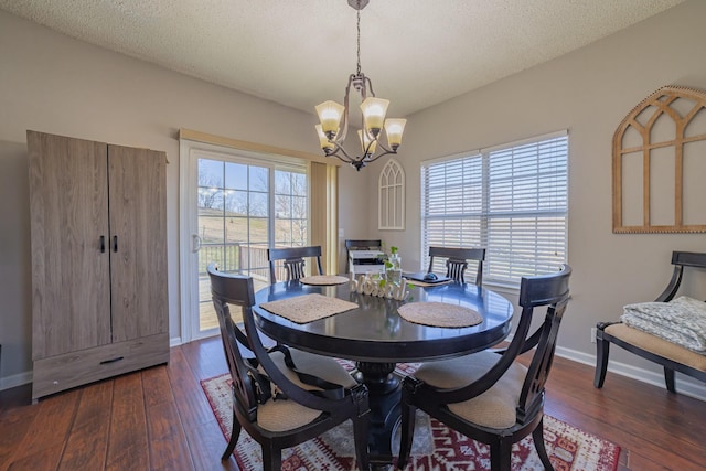 dining room with a wealth of natural light, dark hardwood / wood-style floors, a chandelier, and a textured ceiling