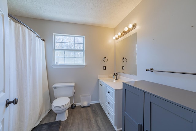 bathroom with hardwood / wood-style floors, vanity, a textured ceiling, and toilet