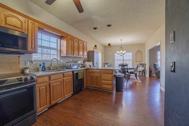 kitchen featuring pendant lighting, sink, dark hardwood / wood-style floors, a textured ceiling, and stainless steel appliances