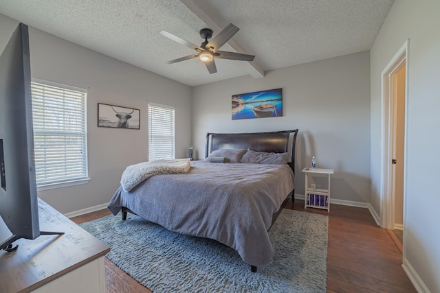 bedroom with beamed ceiling, ceiling fan, a textured ceiling, and dark wood-type flooring