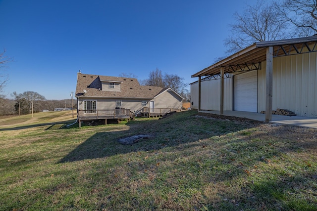 view of yard featuring a wooden deck, an outdoor structure, and a garage