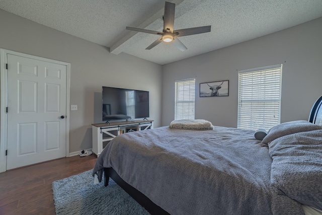 bedroom with a textured ceiling, ceiling fan, beamed ceiling, and dark hardwood / wood-style floors