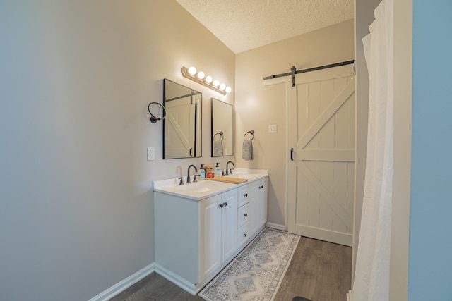 bathroom with vanity, wood-type flooring, and a textured ceiling