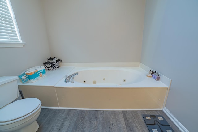 bathroom featuring a bathing tub, toilet, and hardwood / wood-style floors