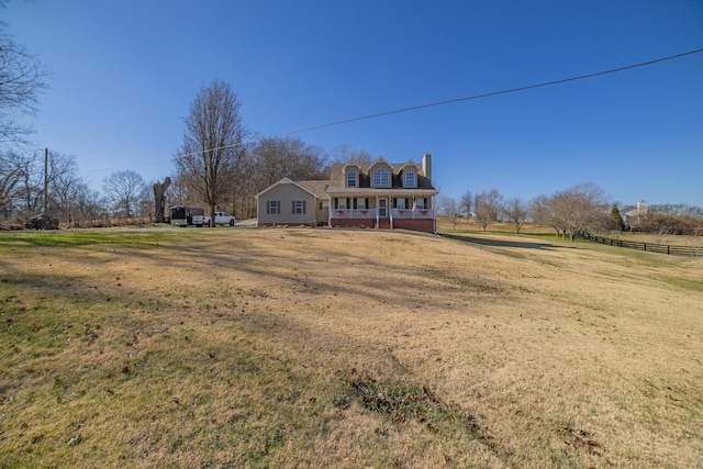 new england style home featuring covered porch and a front lawn