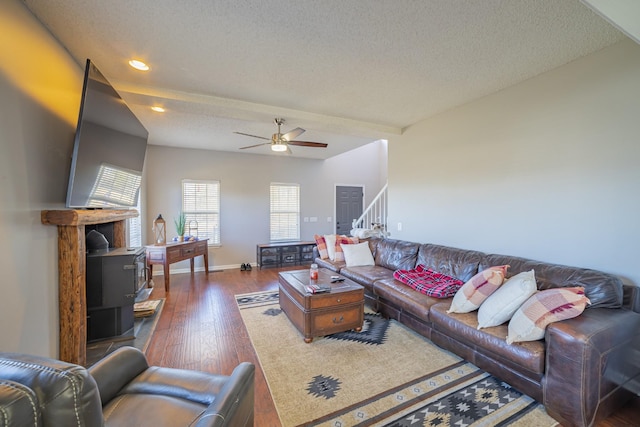 living room with ceiling fan, dark hardwood / wood-style flooring, and a textured ceiling