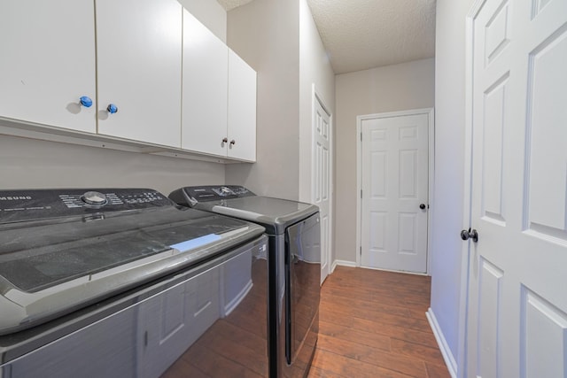 laundry room with cabinets, a textured ceiling, and separate washer and dryer