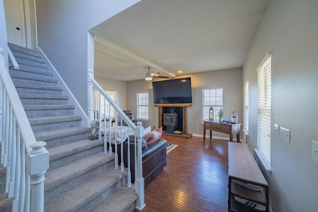 staircase with hardwood / wood-style flooring, ceiling fan, and a textured ceiling