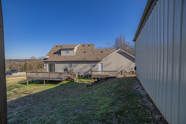 rear view of property with a deck and a lawn