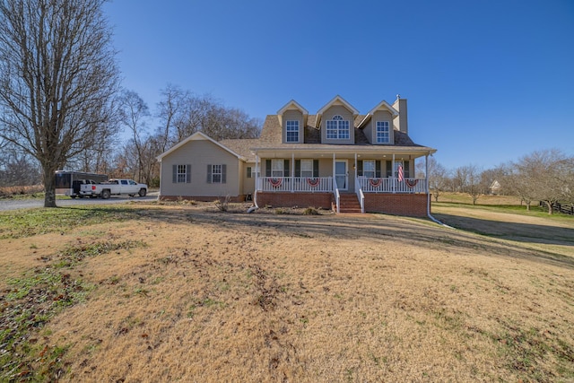 cape cod home with a front yard and a porch