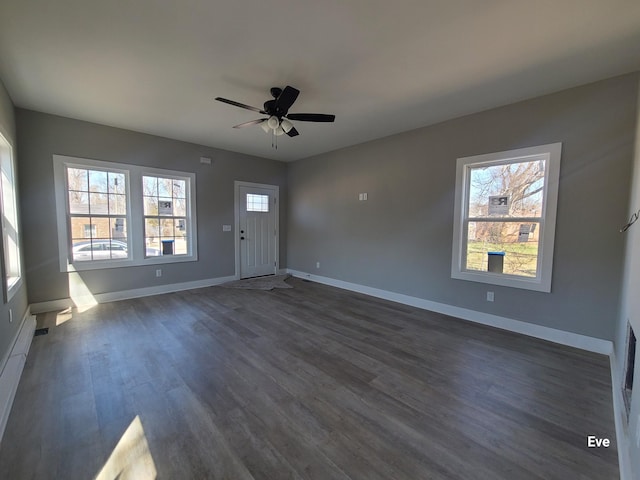 interior space with dark wood finished floors, baseboards, a wealth of natural light, and ceiling fan