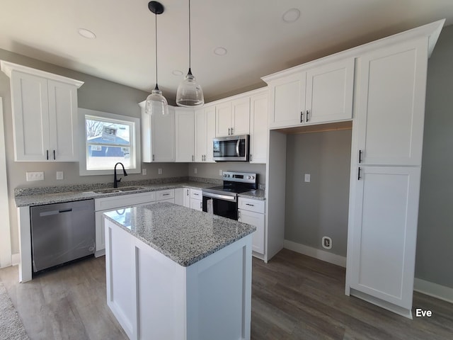 kitchen featuring a sink, stainless steel appliances, a kitchen island, and white cabinetry