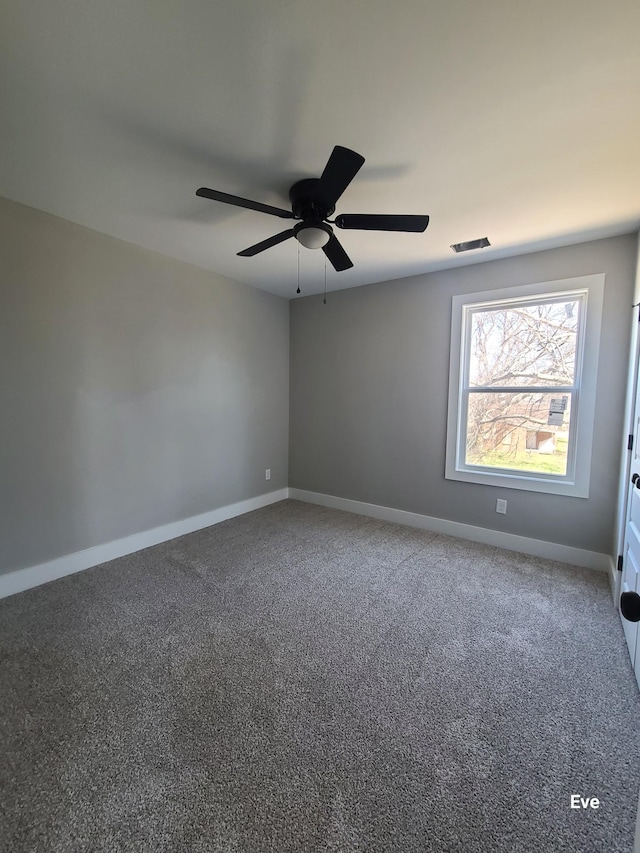 carpeted spare room featuring visible vents, baseboards, and a ceiling fan