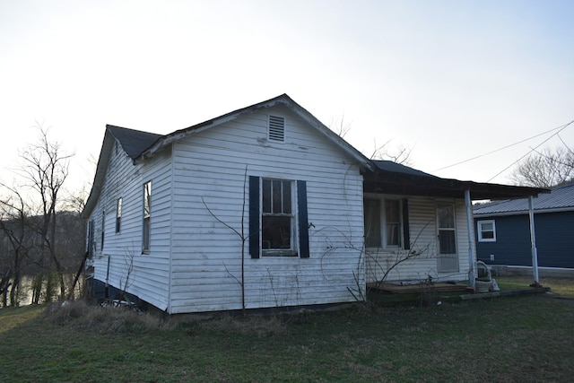 exterior space featuring covered porch and a front lawn