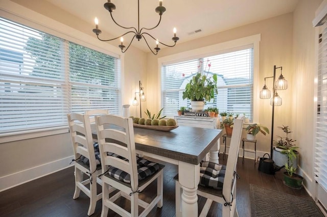 dining space featuring an inviting chandelier, wood finished floors, visible vents, and a wealth of natural light