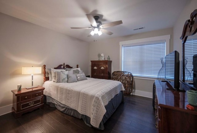 bedroom featuring dark wood finished floors, visible vents, a ceiling fan, and baseboards