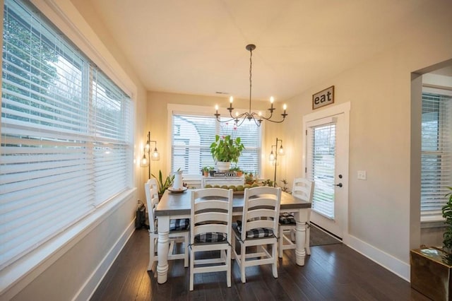 dining space with hardwood / wood-style flooring, baseboards, and a chandelier