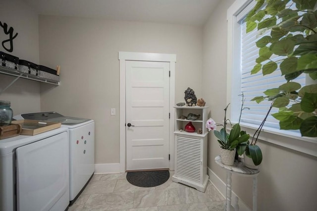 laundry room with laundry area, washing machine and dryer, and baseboards