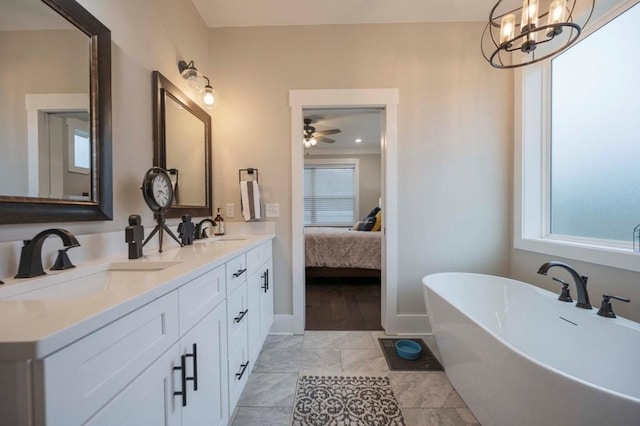 full bathroom with a freestanding bath, plenty of natural light, and a sink