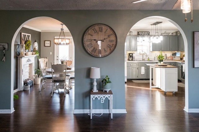 dining space featuring a textured ceiling, dark hardwood / wood-style floors, a notable chandelier, and sink