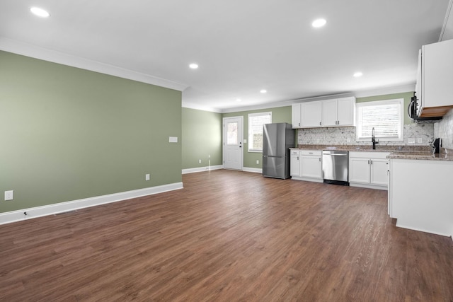 kitchen with backsplash, dark hardwood / wood-style flooring, white cabinetry, appliances with stainless steel finishes, and sink