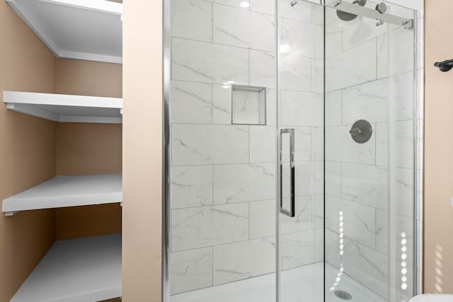 bathroom with an enclosed shower and ornamental molding