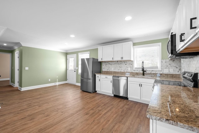 kitchen with sink, appliances with stainless steel finishes, a wealth of natural light, and white cabinetry