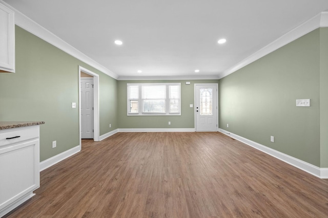 unfurnished living room featuring hardwood / wood-style floors and ornamental molding