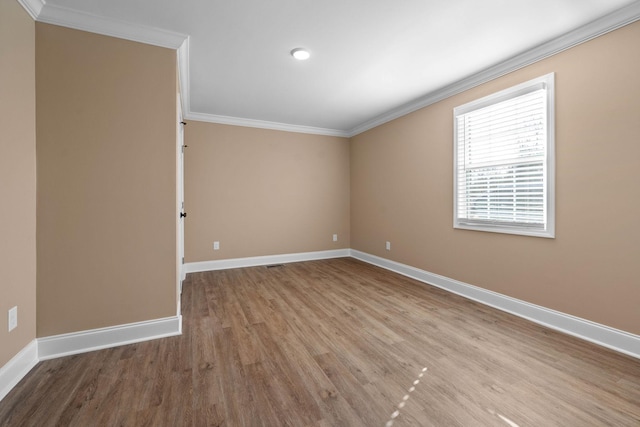 spare room featuring light hardwood / wood-style floors and crown molding