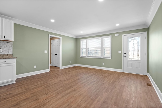 foyer with light hardwood / wood-style flooring and crown molding