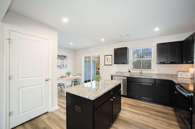 kitchen featuring dishwasher, sink, light hardwood / wood-style floors, black / electric stove, and a kitchen island