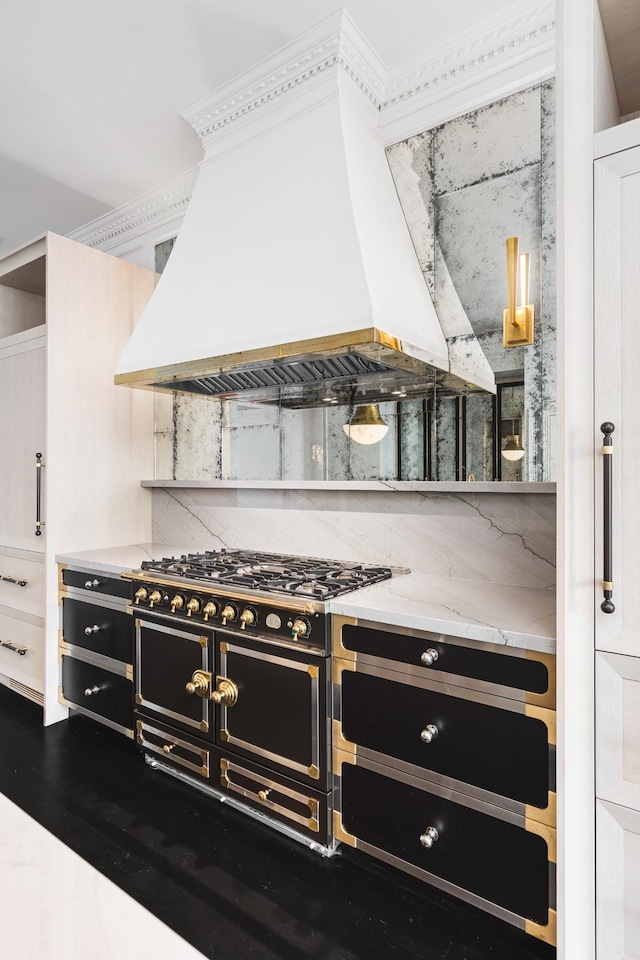 kitchen with light stone counters, stovetop, decorative backsplash, white cabinets, and custom range hood