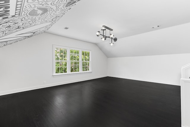 bonus room featuring a chandelier, lofted ceiling, and hardwood / wood-style flooring