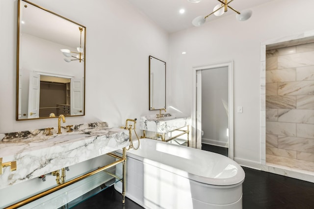 bathroom featuring vanity, independent shower and bath, and a chandelier