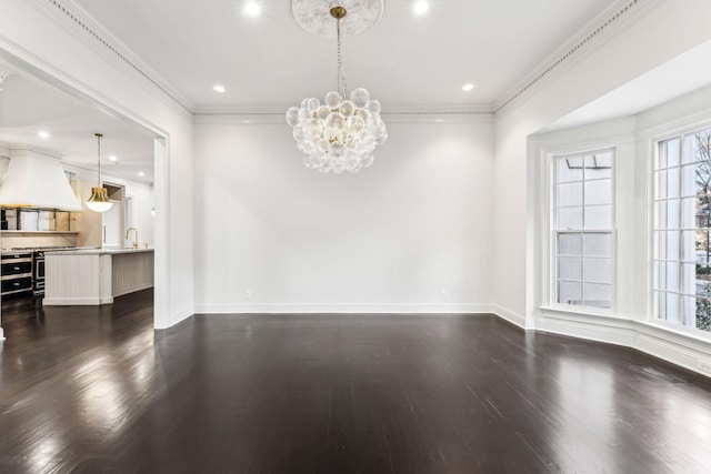 spare room featuring crown molding, dark hardwood / wood-style floors, and an inviting chandelier