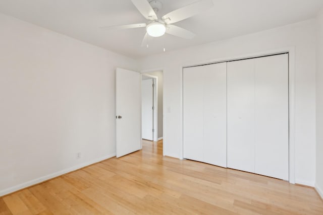 unfurnished bedroom with ceiling fan, a closet, and hardwood / wood-style floors