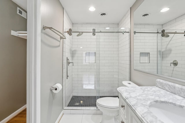 bathroom with tile patterned floors, toilet, a shower with door, and vanity