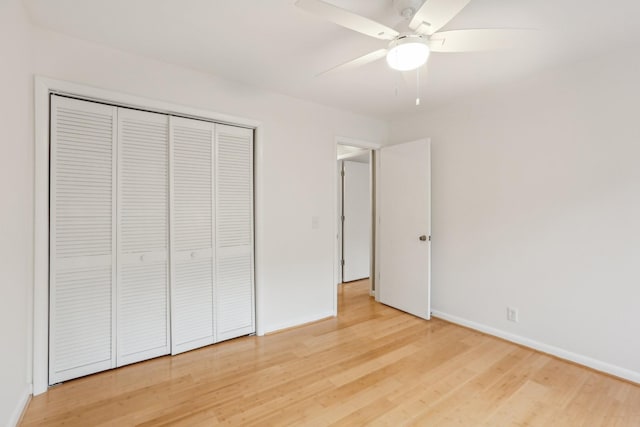 unfurnished bedroom with ceiling fan, wood-type flooring, and a closet