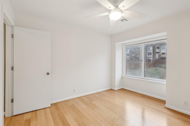 spare room with light wood-type flooring and ceiling fan