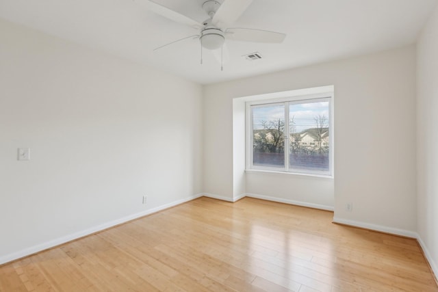 empty room with ceiling fan and light hardwood / wood-style flooring